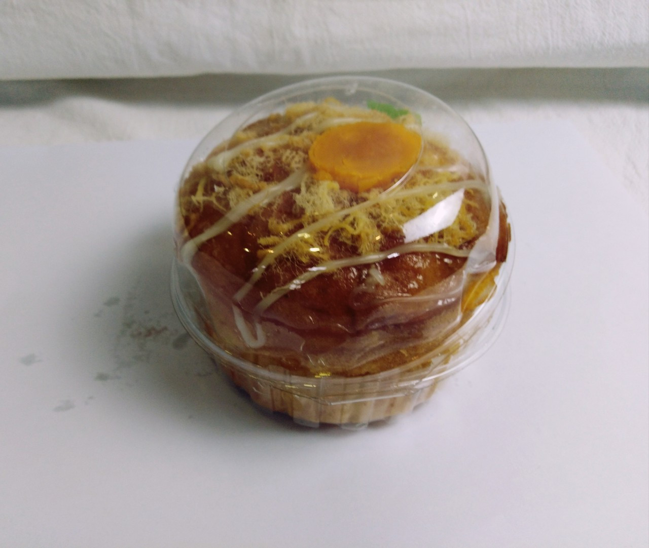 Bánh bông lan trứng muối nhỏ hộp trong suốt với lớp sốt và trứng muối vàng ươm