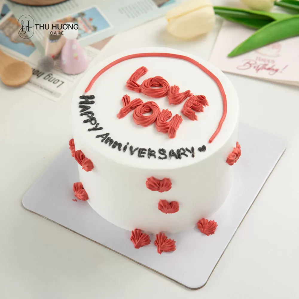 Bánh kem anniversary mini tông màu trắng hồng, điểm xuyết trái tim và chữ viết tay