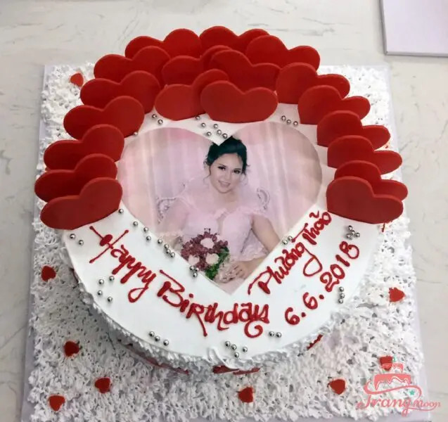 Bánh kem in hình cá nhân hóa với ảnh vợ chồng, thể hiện sự quan tâm đặc biệt.