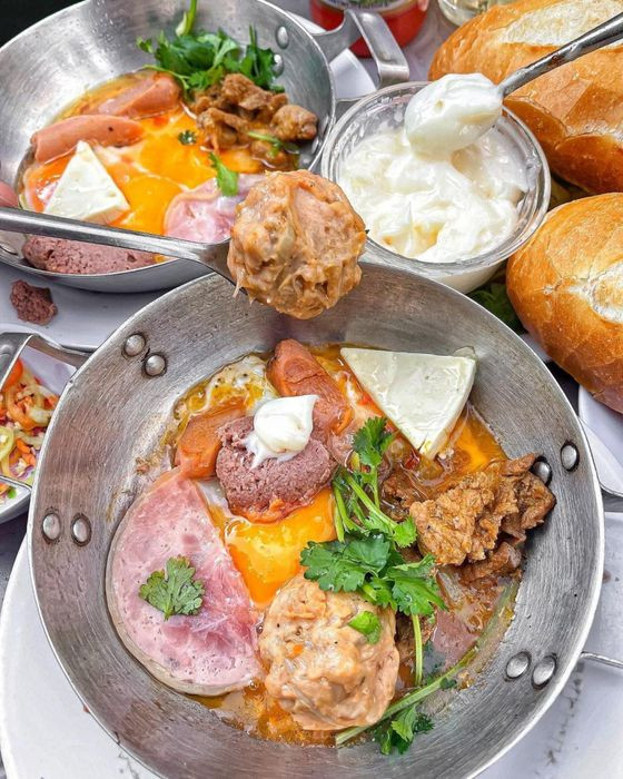Bánh mì chảo thập cẩm đầy ắp tại quán Dì Nữ Quận 1, với trứng ốp la, xíu mại, pate.
