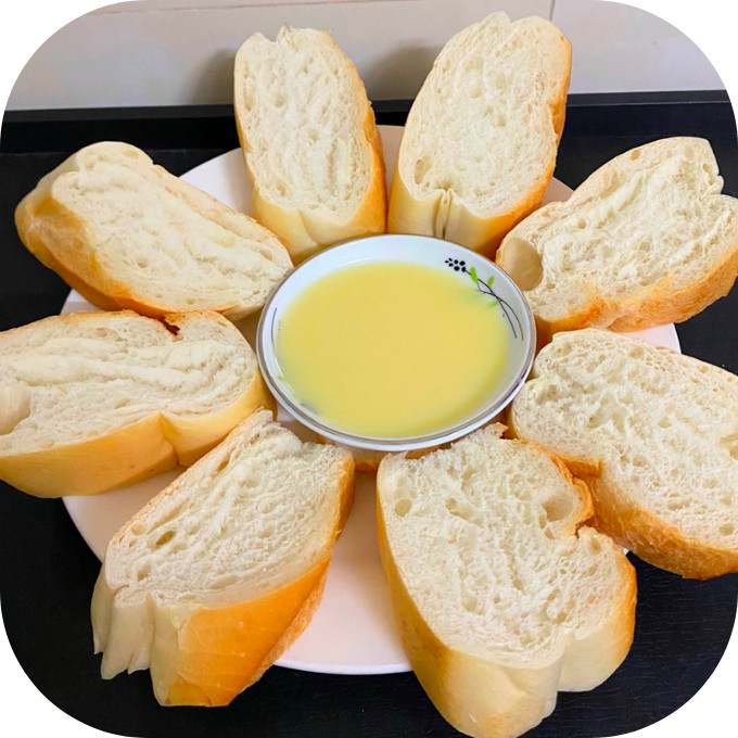 Bánh mì giòn tan được chấm vào bát sữa đặc ngọt ngào