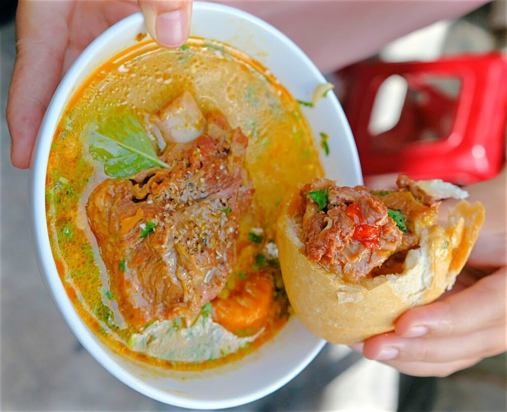 Bánh mì lagu thơm ngon, đậm đà tại một quán bánh mì, là sự kết hợp hoàn hảo giữa bánh mì giòn và nước lagu nóng hổi.