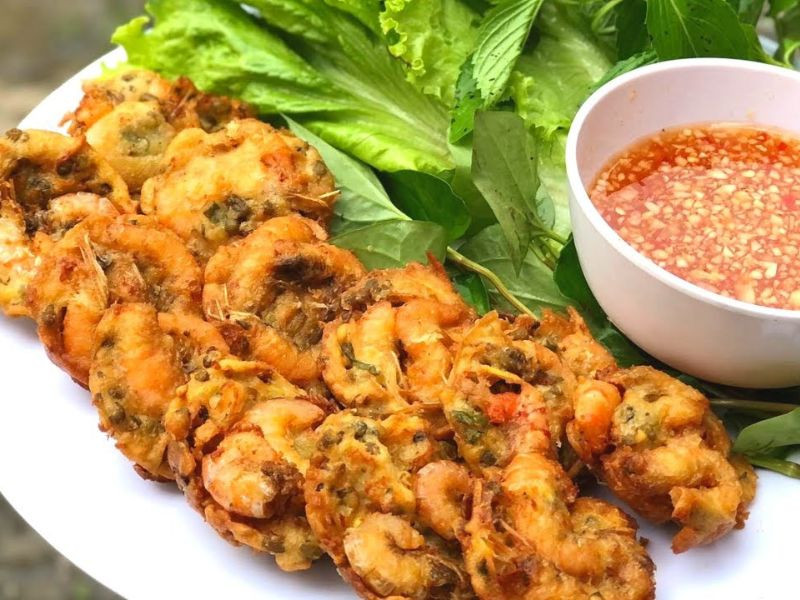 Bánh tôm chiên vàng giòn trong chảo dầu nóng