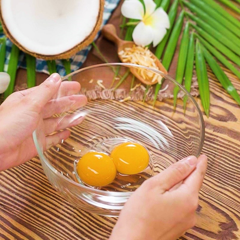 Bát lớn chứa lòng đỏ trứng gà, dầu ăn, nước cốt dừa, bột mì và bột bắp đang được trộn đều để làm cốt bánh kem trứng dừa nướng.