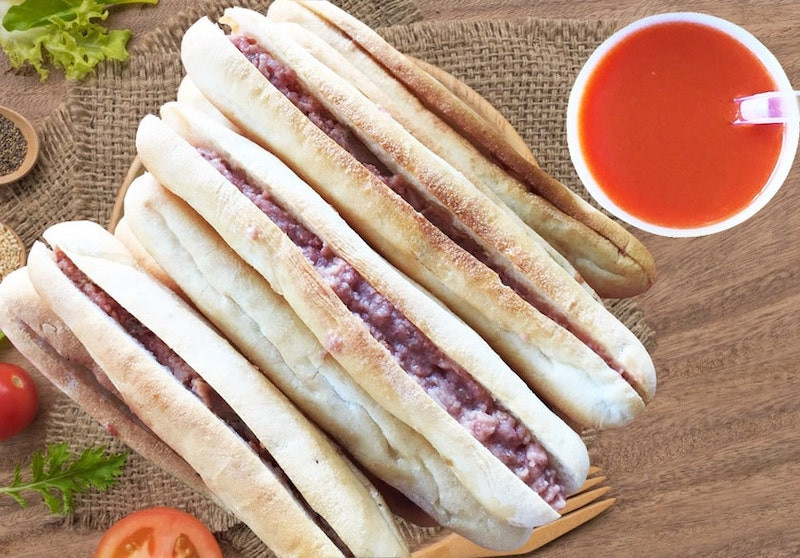 Bên trong bánh mì que Bà Già bạn sẽ tìm thấy một sự kết hợp hài hòa của lớp bơ mỏng, chà bông thơm ngon, pate mịn màng, rau thơm tươi mát và một chút đu đủ để tạo sự cân bằng tuyệt vời