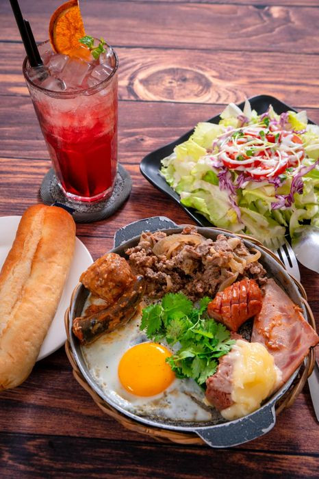 Combo bánh mì chảo thập cẩm tại Bò Chảo Tân Định, đầy đủ thịt bò, trứng và pate, địa điểm ăn sáng Quận 1.