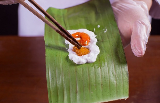 Đặt nhân tôm thịt vào giữa phần bột đã phết trên lá chuối để gói bánh bột lọc