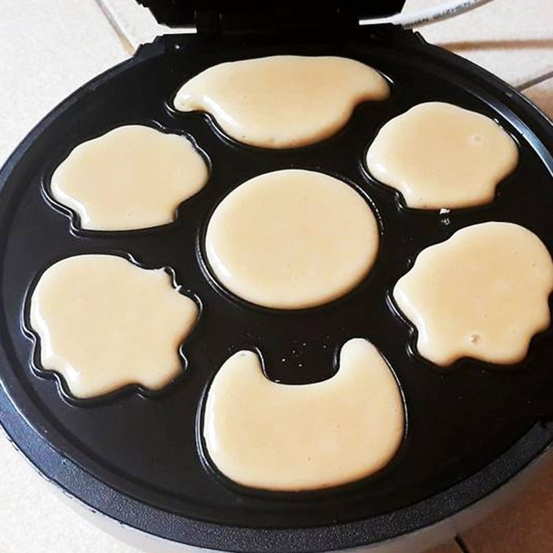 Đổ bột làm bánh bông lan hình thú vào khuôn nướng
