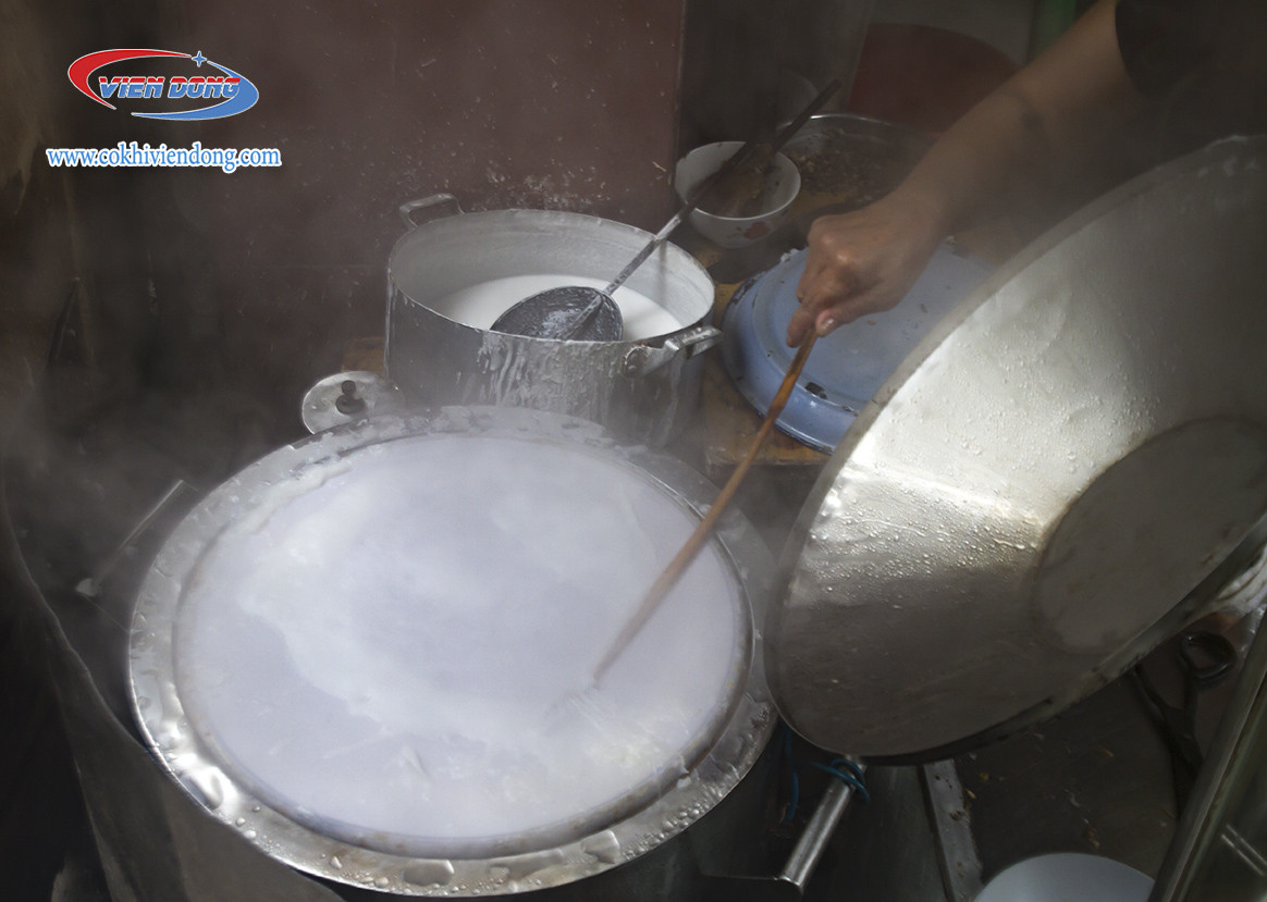 Dòng bột bánh cuốn đang được khuấy đều trong một chiếc chậu lớn, chuẩn bị cho quá trình tráng bánh
