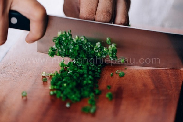 Hành lá thái nhỏ chuẩn bị làm nước xốt cho món bánh mì nướng muối ớt