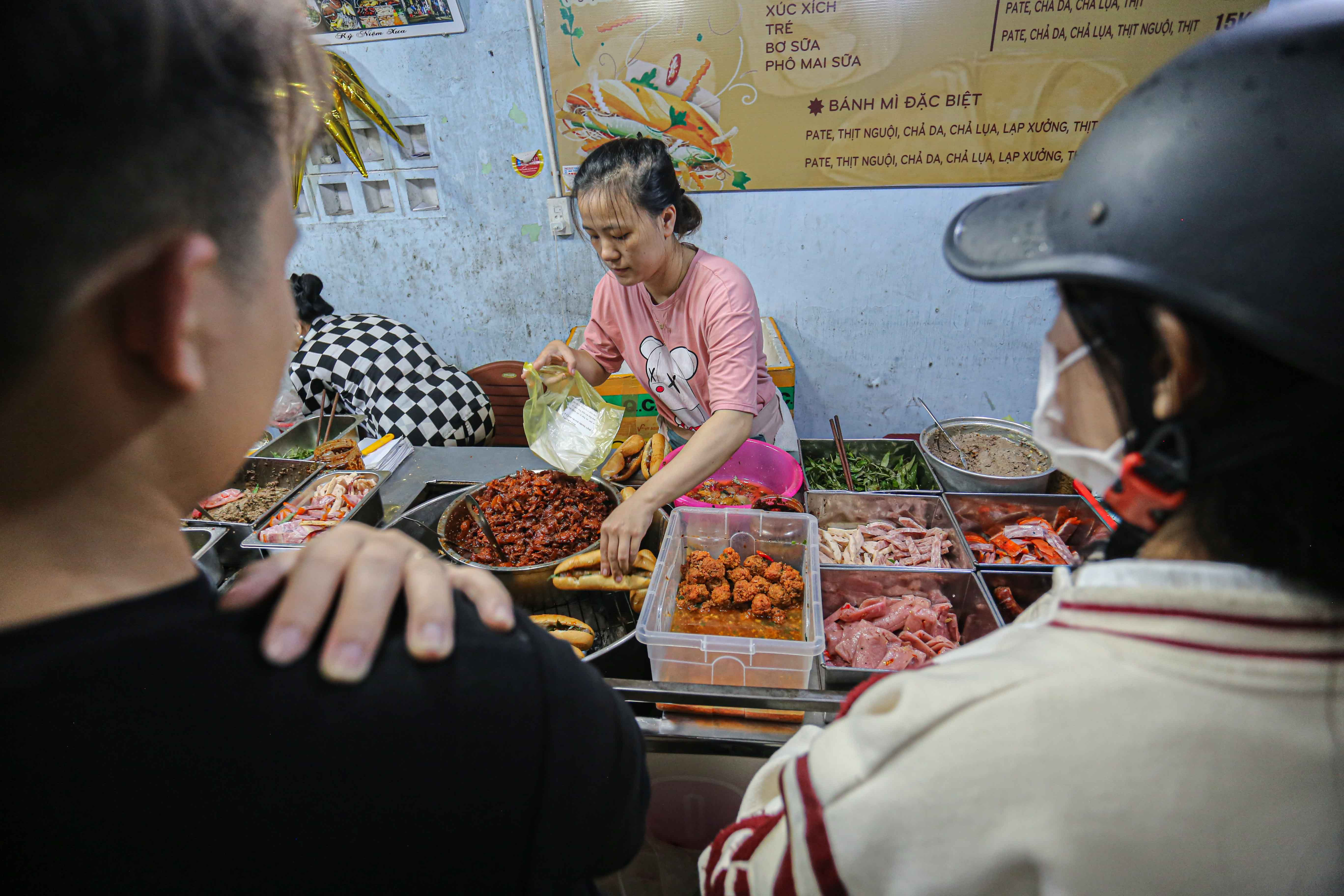 Khách hàng kiên nhẫn chờ đợi món bánh mì O Tho Huế đêm khuya