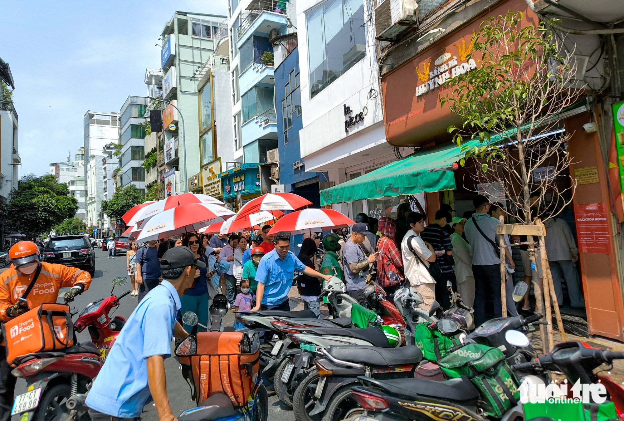 Khách hàng và xe máy đông đúc tràn ra đường tại địa chỉ bánh mì Huỳnh Hoa