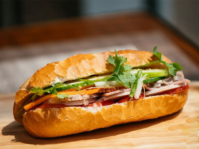 Người phụ nữ đang thưởng thức bánh mì, tìm hiểu ăn bánh mì có béo không và cách kiểm soát calo