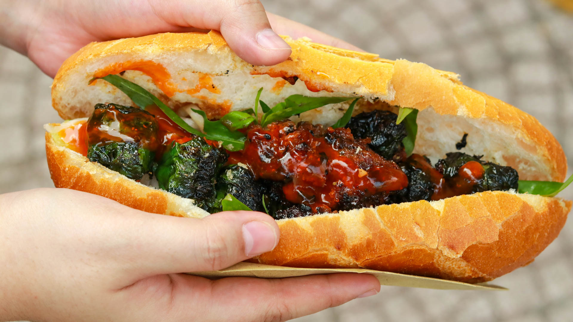 Ổ bánh mì bò lá lốt hoàn chỉnh với nhân bò nướng thơm lừng, rau sống và nước sốt đặc biệt