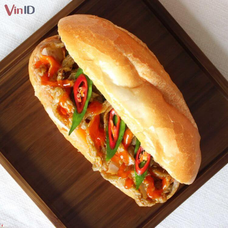 Ổ bánh mì chả cá nóng hổi, giòn rụm, chan đầy nước sốt chua ngọt hấp dẫn