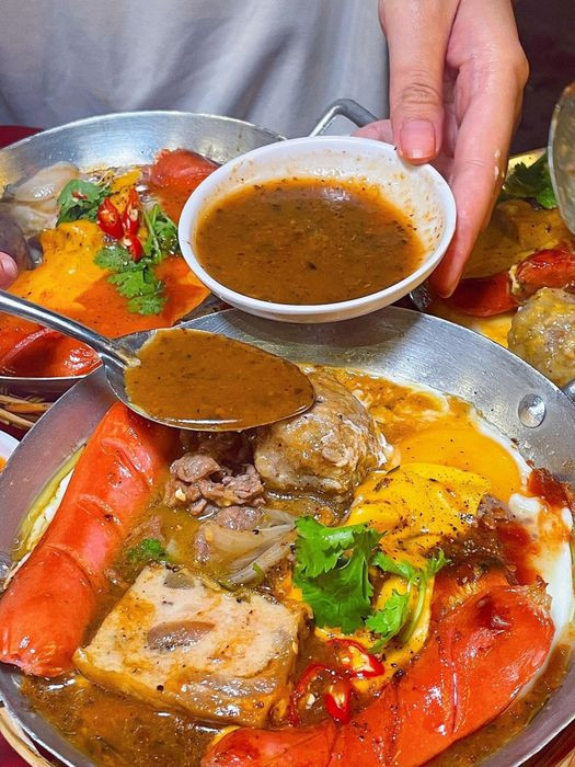Phần bánh mì chảo Bến Thành với bánh mì than tre độc đáo, trứng ốp la và khoai tây chiên, món ngon Quận 1.