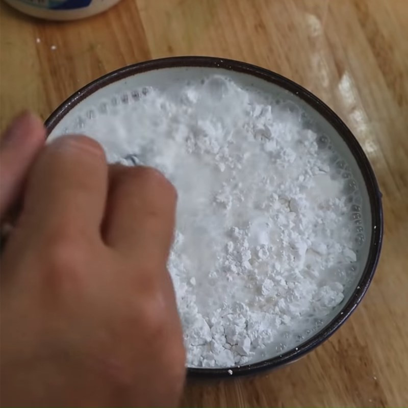 Tô lớn chứa hỗn hợp bột bánh da lợn truyền thống màu xanh lá dứa đang được khuấy đều