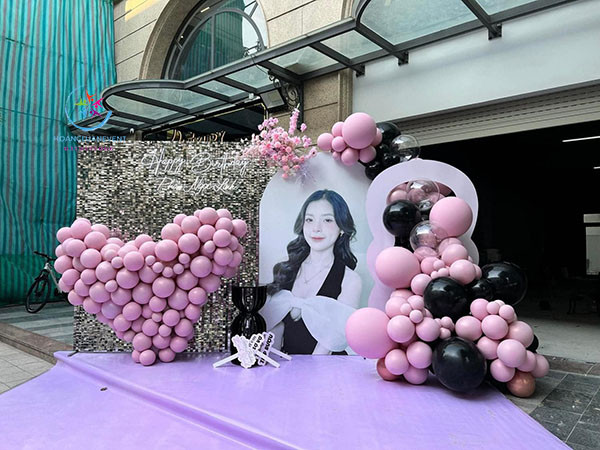Backdrop sinh nhật người lớn với tông màu xanh dương pastel và trắng, điểm xuyết bóng bay trắng và bạc, tạo cảm giác nhẹ nhàng, tinh tế.