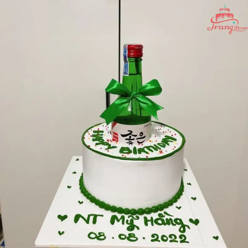 Bánh kem hình chai rượu đang được trang trí