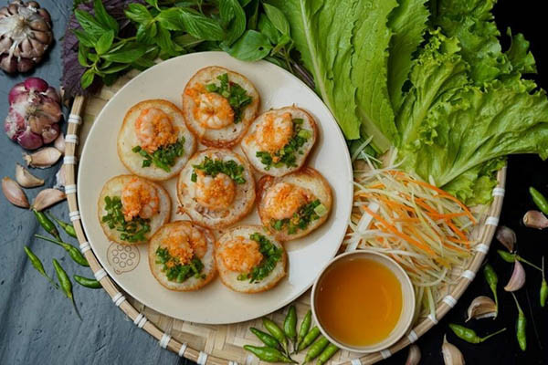 Bánh khọt vàng giòn ăn kèm rau sống và nước chấm chua ngọt hấp dẫn