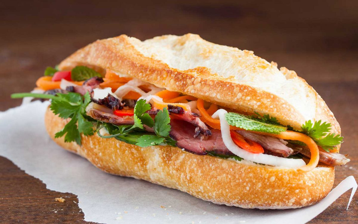 Bánh mì Việt Nam truyền thống với nhân thịt và rau thơm tươi ngon, món ăn đường phố phổ biến.