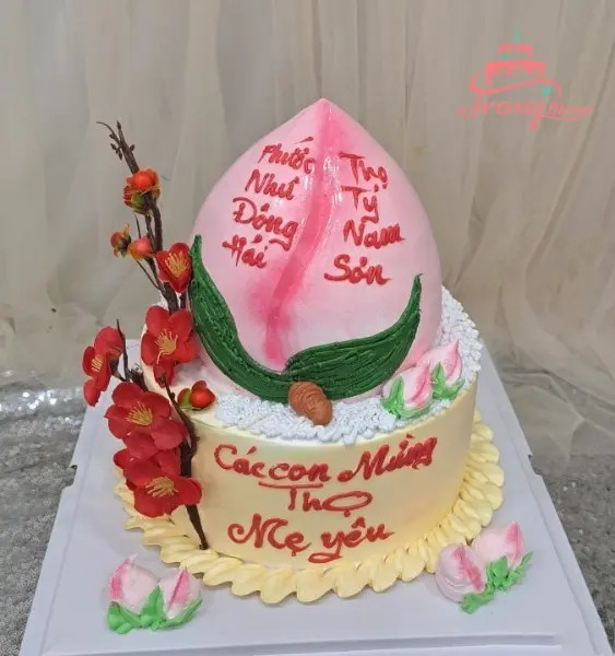 Bánh sinh nhật bà trang trí hình hoa sen và dòng chữ "Kính mừng thọ mẹ yêu", gửi gắm tình cảm chân thành.
