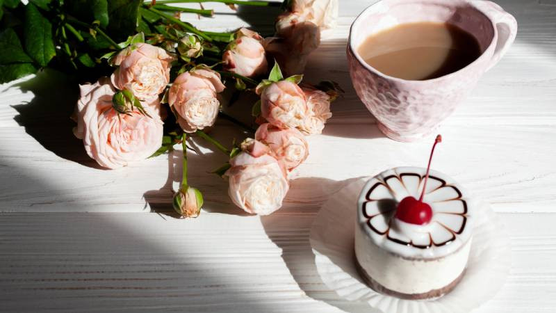Bánh sinh nhật trên bàn gỗ với hoa tươi