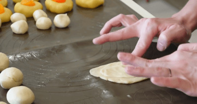 cán mỏng bột vỏ bánh và bột dầu để tạo lớp vỏ bánh pía