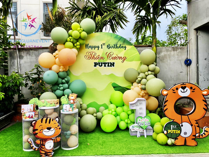 decor sinh nhật bé trai chủ đề rừng xanh với backdrop lớn và bàn tiệc trang trí sinh động