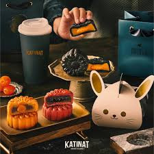 Hộp bánh trung thu Katinat Coffee 2024 với thiết kế hình chú thỏ và họa tiết hoa văn nghệ thuật, bên cạnh tách cà phê