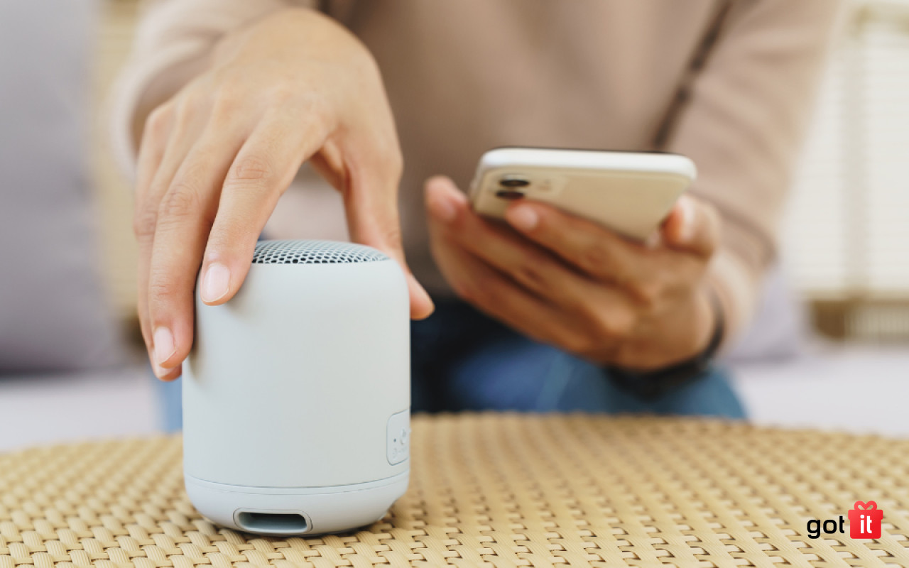 Một chiếc loa bluetooth nhỏ gọn màu đen đặt trên bàn gỗ