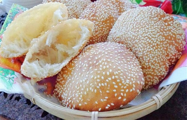 Những chiếc bánh tiêu vàng giòn, nở phồng đang được chiên trong chảo dầu