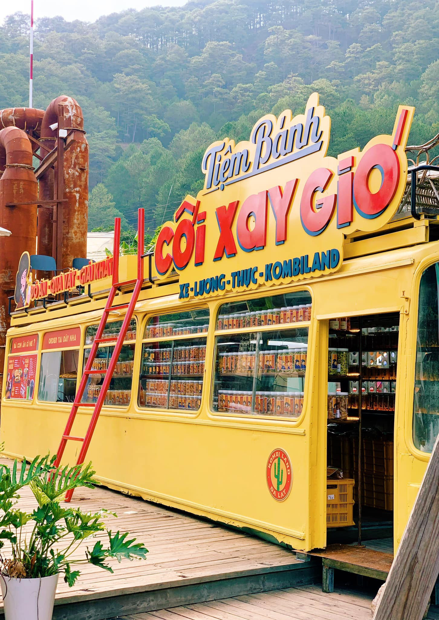 Xe lương thực màu vàng nổi bật giữa vườn xương rồng Kombi Land của Cối Xay Gió